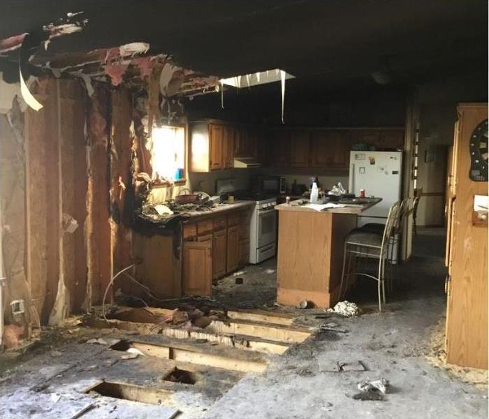 kitchen with fire damage and insulation falling from the ceiling