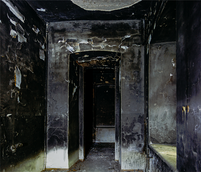 a fire damaged hallway with soot covering the walls