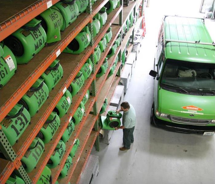 warehouse with SERVPRO equipment, a technician, and a van