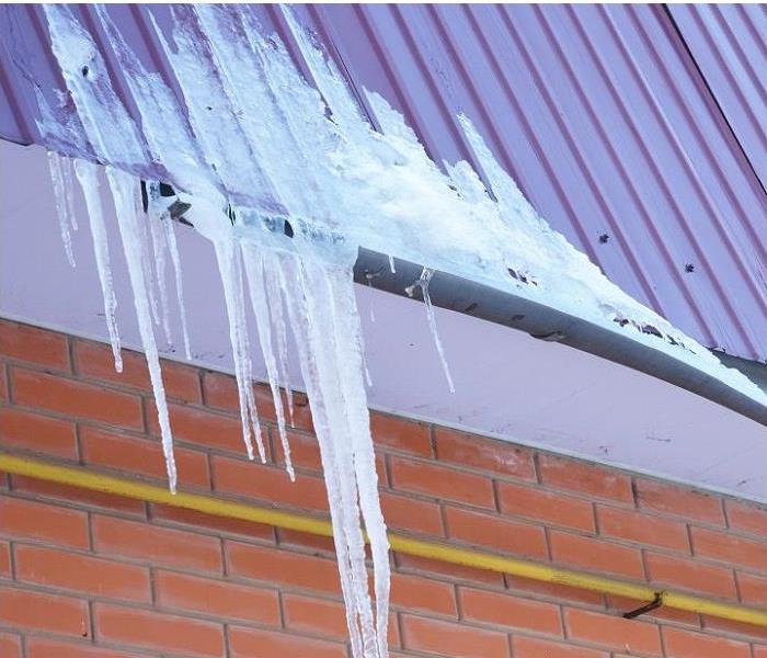 Frozen water in rain gutter; ice on roof