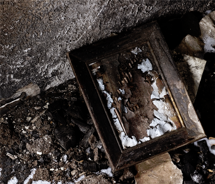 a burned picture frame among more burned rubble